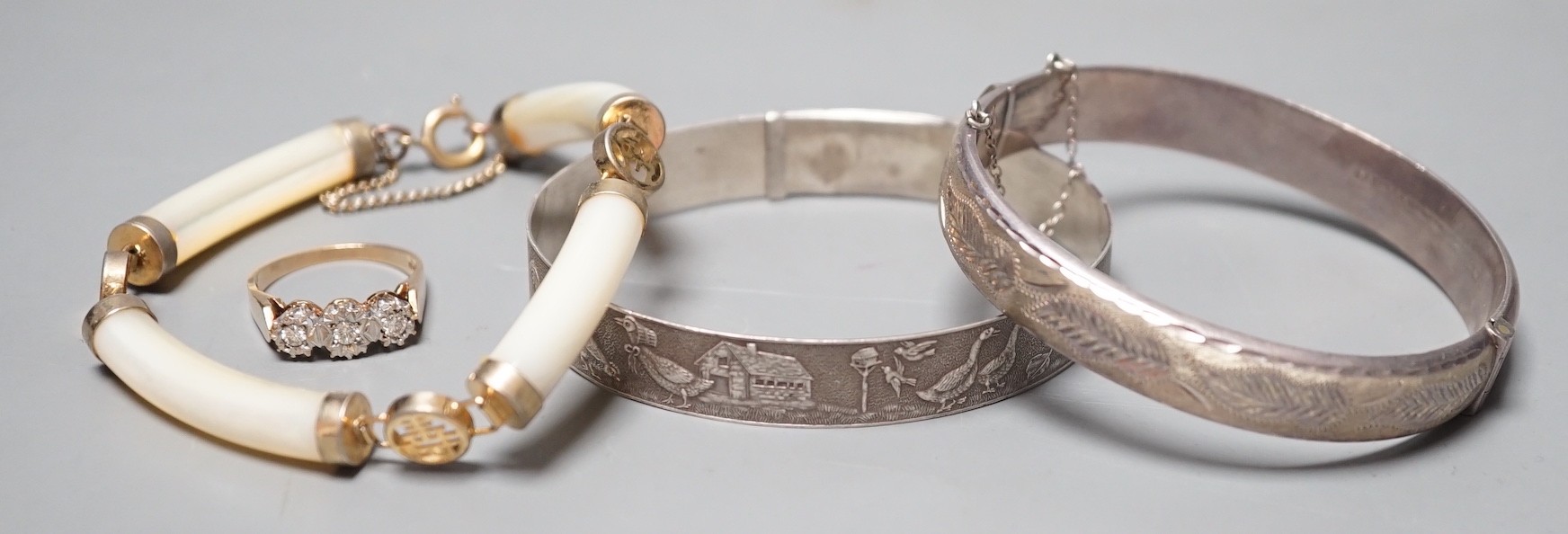 A modern 9ct gold and illusion set three stone diamond ring, size N/O, a Chinese gilt metal and mother of pearl bracelet and two white metal bangles, one hallmarked silver.